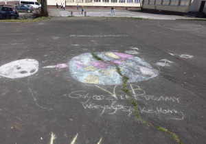 Rysunek i hasło promujące ochronę Ziemi wykonane kredą przez uczniów z klasy 5b na boisku szkolnym – Gdy o Ziemię dbamy wszyscy się kochamy