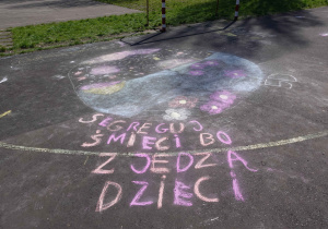 Napis wykonany kredą na asfalcie – „Segreguj śmieci bo zjedzą dzieci”