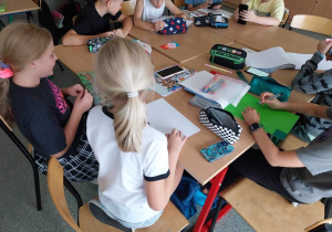 Uczniowie klasy 4c pracują nad projektem przygotowując plakaty zawierające tłumaczenie kolorów w języku hiszpańskim i włoskim
