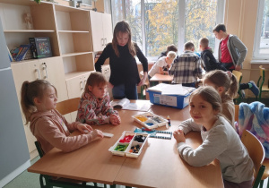 Uczniowie klas szóstych pomagają uczniom z klasy drugiej w złożeniu modeli z zestawów Lego Education Bricq