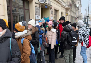 Grupa uczniów stoi przed wejściem do Muzeum Światła