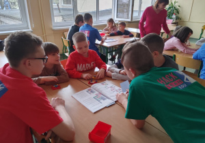 Uczniowie z klas szóstych i siódmych pomagają przedszkolakom w tworzeniu robota Lego Spike.