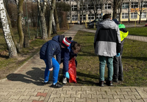 Uczniowie z klasy 5a sprzątają teren wokół szkoły