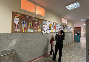 Goście oglądają prace uczniów klas 4 i 5 na szkolnych korytarzach