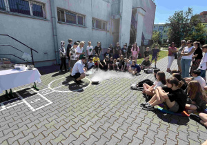 Prowadzący warsztaty na szkolnym boisku przygotowują lody przy zastosowaniu ciekłego azotu.