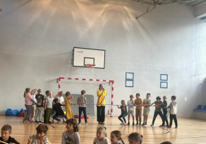 Dzieci uczestniczą w zajęciach sportowych – przeciąganie liny.