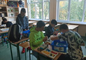 Uczniowie z klocków Lego budują roboty.
