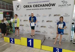 Barbara Kowalczyk - 1 miejsce 25m stylem grzbietowym. Zawodniczka stoi na podium.