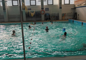 Dzieci uczestniczą w zajęciach na pływalni