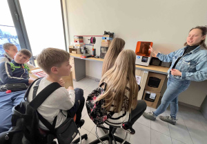 Grupa uczniów uczestniczy w warsztatach dotyczących Technologii Druku 3D