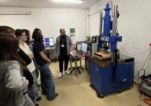 Uczennice stoją w laboratorium mechanicznym i poznają praktyczne zastosowanie inżynierii materiałowej w sytuacjach ratunkowych.