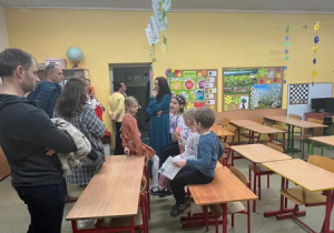 Dzieci i ich rodzice odwiedzają sale lekcyjne.