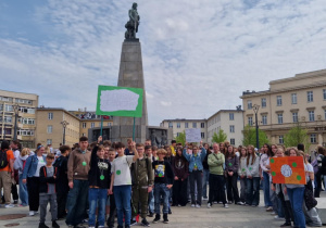 Uczniowie stoją na Placu Wolności z przygotowanymi transparentami i oczekują na rozpoczęcie Marszu.