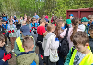 Uczniowie klas czwartych wraz z opiekunami przygotowują się do sprzątania lasu.