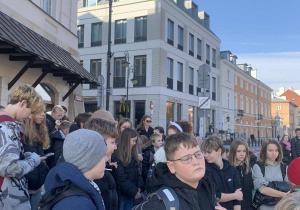 Uczniowie zwiedzają Stare Miasto w Warszawie.