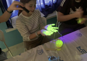 Uczestnicy wycieczki z klas piątych i szóstych uczestniczą w warsztatach fluorescencyjnych w centrum "Mały inżynier" w Warszawie.
