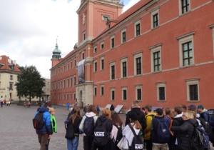 Uczniowie stoją na Placu Zamkowym w Warszawie