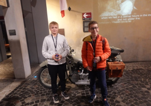 Dwóch uczniów z klasy 8a znajduje się w sali, w której został umieszczony niemiecki motocykl.i