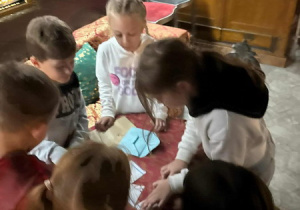 Uczniowi składają puzzle.