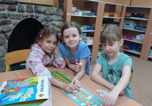Trzy uczennice zajęć logopedycznych grają w grę „Drabina logopedyczna”.