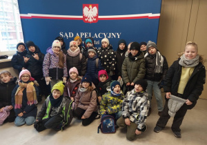 Wspólne zdjęcie uczniów klasy 2a na tle napisu Sąd Apelacyjny.