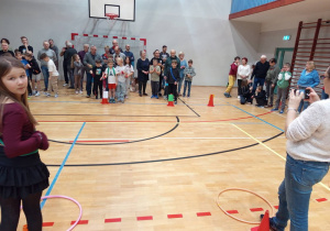 Uczestnicy konkurencji sportowych, w wybranych drużynach czekają na sali gimnastycznej na rozpoczęcie pierwszej konkurencji.