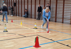 Każda z drużyn pokonuje slalom między pachołkami , prowadząc piłkę kijem do unihokeja.
