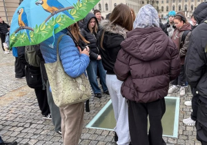 Uczestnicy wycieczki stoją przy Pomniku Spalonych Książek w Berlinie na Bebelplatz