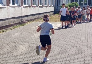 Zawody klas młodszych na szkolnym boisku – wyścigi z butelkami.