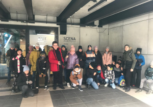 Uczniowie stoją przed głównym wejściem do teatru.