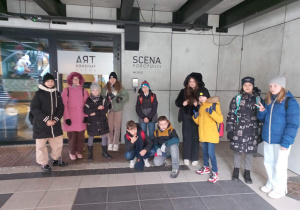 Uczniowie stoją przed głównym wejściem do teatru.