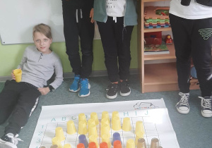 chłopcy zakodowali obrazek kubeczkami