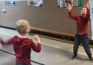 Zabawy sportowe z udziałem najmłodszych gości na szkolnym korytarzu