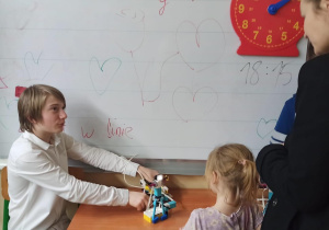 Uczeń z klasy szóstej prezentuje przedszkolakom roboty