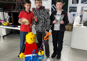 Grupa uczniów z nagrodami. Na pierwszym planie duży Ludzik Lego.