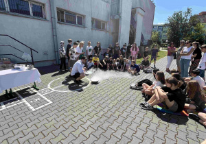 Prowadzący warsztaty na szkolnym boisku przygotowują lody przy zastosowaniu ciekłego azotu.