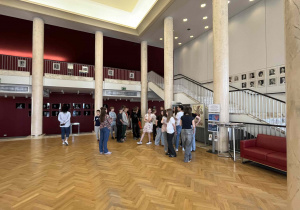 Uczestnicy wycieczki przebywają w reprezentacyjnym foyer Teatru Wielkiego.