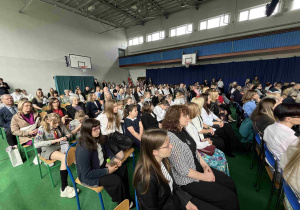 Zgromadzeni goście, nauczyciele, uczniowie, absolwenci, rodzice na sali gimnastycznej podczas Jubileuszu