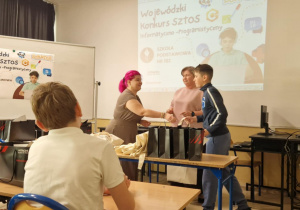 Uczestnicy konkursu informatycznego odbierają nagrody od organizatorów.