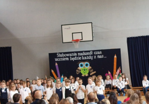 Uczniowie klas pierwszych recytujący wiersze w czasie części artystycznej.