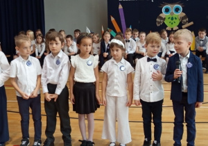 Uczniowie klas pierwszych recytujący wiersze w czasie części artystycznej.