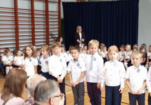 Uczniowie klas pierwszych recytujący wiersze w czasie części artystycznej.