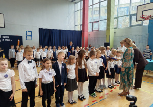 Uczniowie klasy 1b są pasowani przez Panią dyrektor Joanne Mrowińską –Wange i przyjmujący gratulacje od wychowawczyni Pani Renaty Brzostowskiej.