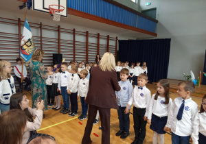 Uczniowie klasy 1b są pasowani przez Panią dyrektor Joanne Mrowińską –Wange i przyjmujący gratulacje od wychowawczyni Pani Renaty Brzostowskiej.