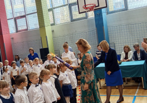 Uczniowie klasy 1a=c są pasowani przez Panią dyrektor Joanne Mrowińską –Wange i przyjmujący gratulacje od wychowawczyni Pani Ireny Osadowskiej.