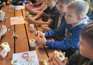 uczniowie wykonują świece z wosku pszczelego i prezentują swoje wyroby.