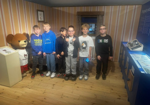 Uczniowie stojący obok Misia Uszatka.