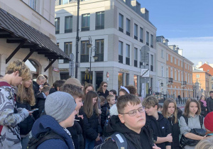 Uczniowie zwiedzają Stare Miasto w Warszawie.