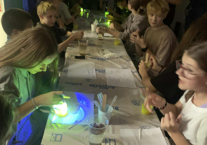 Uczestnicy wycieczki z klas piątych i szóstych uczestniczą w warsztatach fluorescencyjnych w centrum "Mały inżynier" w Warszawie.