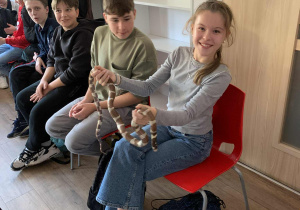 Uczniowie podczas warsztatów w Łódzkim Ogrodzie Zoologicznym trzymają węża zbożowego.